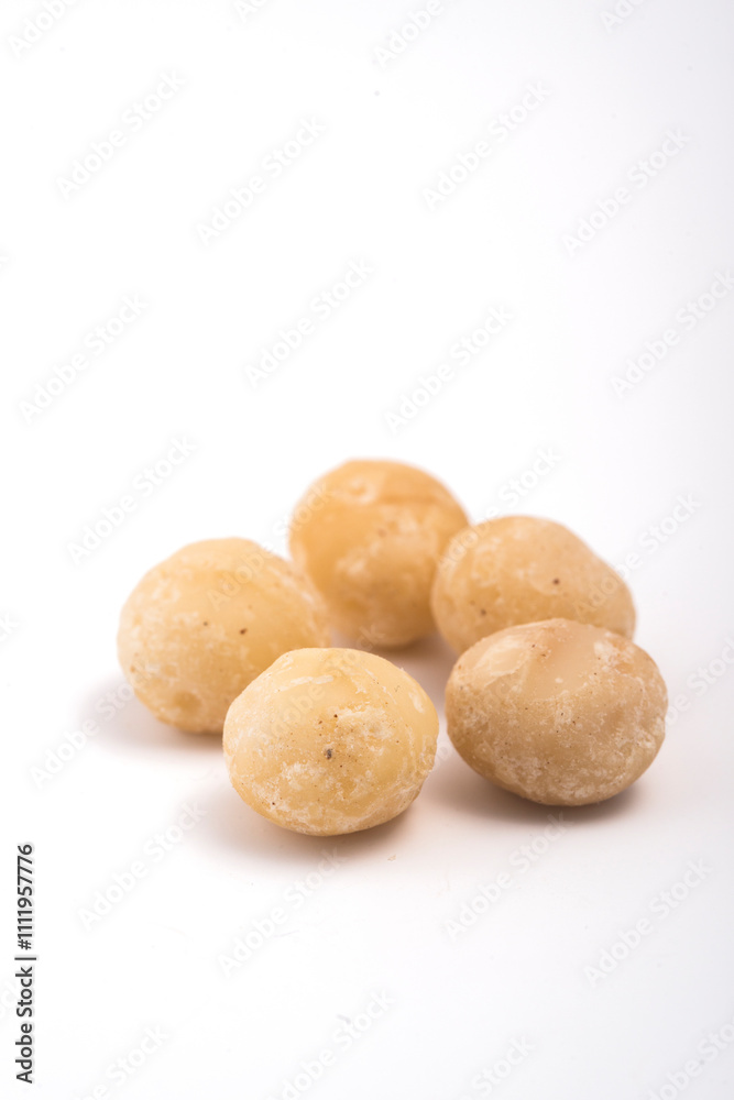 Macadamia nuts on white background. Selective focus with shallow depth of field. Macadamia nuts on white background. Selective focus with shallow depth of field.