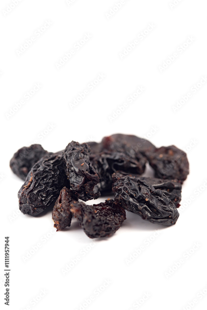 Black raisins on a white background. Dried fruits. Black raisins on a white background. Dried fruits.