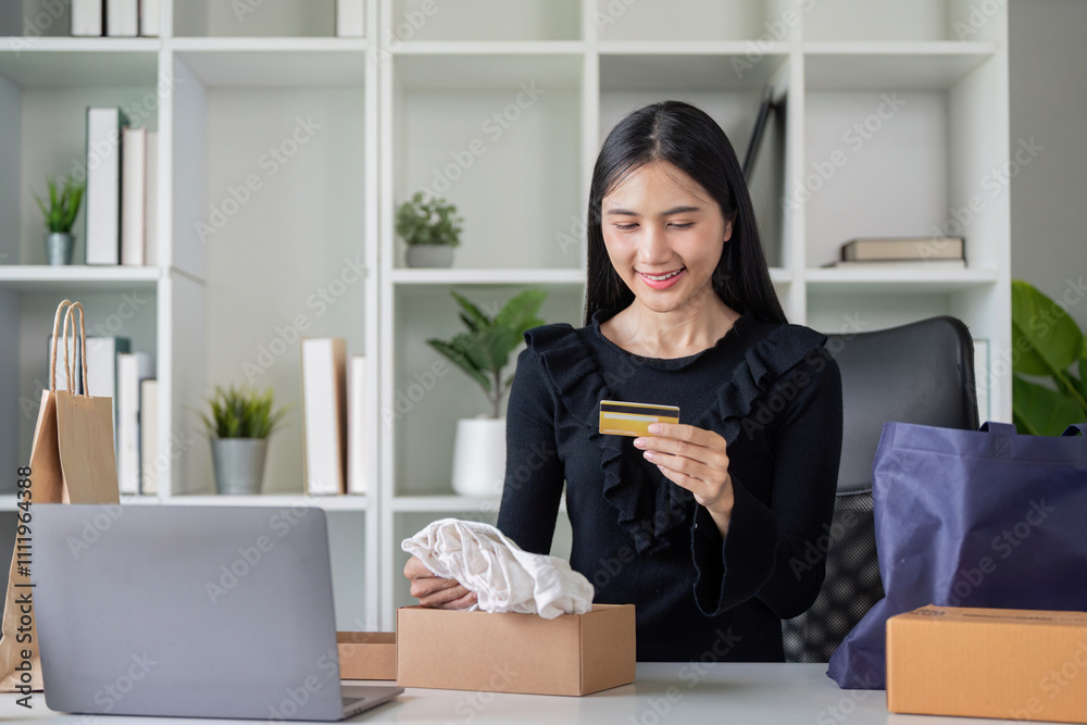 Asian woman unboxing online purchase with credit card in hand Asian woman unboxing online purchase with credit card in hand