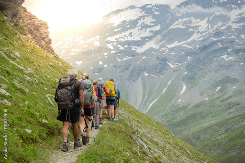 A group of senior hikers with backpacks walk in the mountains. photo