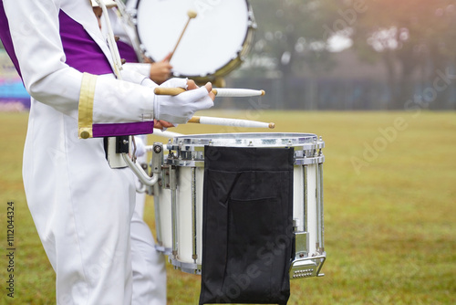 Marching band drummer plays music during the school sports day parade. Soft and selective focus.