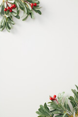 Minimalist Christmas vertical banner design with green foliage and red berries on a clean white background. Perfect for holiday themes, invitations, and elegant designs
