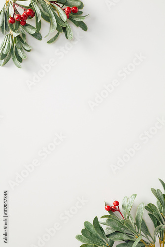 Minimalist Christmas vertical banner design with green foliage and red berries on a clean white background. Perfect for holiday themes, invitations, and elegant designs photo