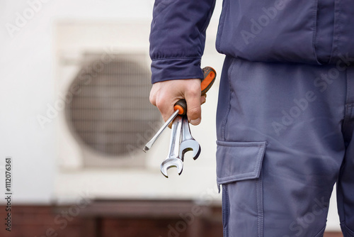 Heat Pump Install Service. Worker Hand with Tools Installing Heat Pump System or Conditioner. photo