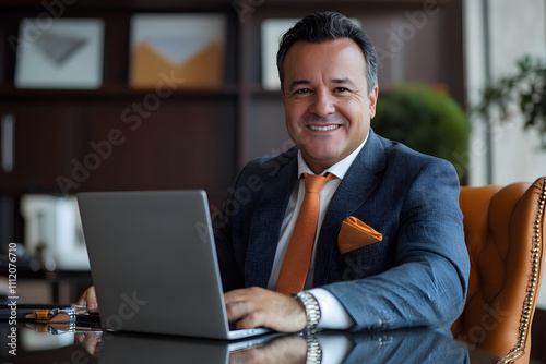 Professional businessman smiling at his desk with laptop in stylish office.