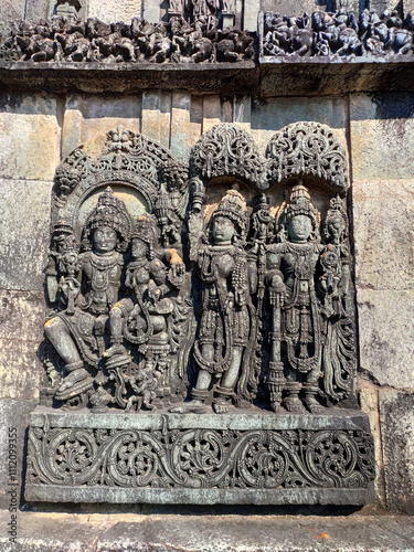 Ornate wall panel reliefs depicting,from left, Vishnu with his consort Lakshmi, Paravati and Shiva. Ranganayaki, Andal, temple, Chennakesava temple complex, Belur, Karnataka, India. West wall.  photo