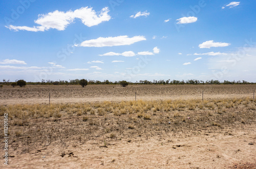 The Expansive Landscape of Dry Desert Terrain is Set Under a Clear and Sunny Sky