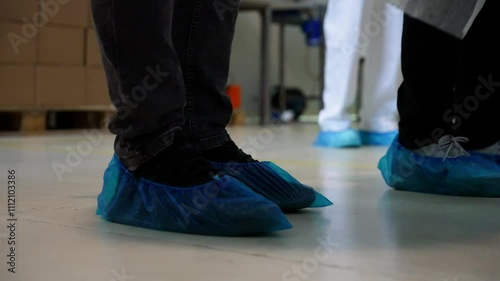 a man putting a shoe covers in a industry or a hospital