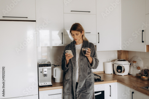 Young woman enjoying fresh aromatic coffee near modern machine in kitchen