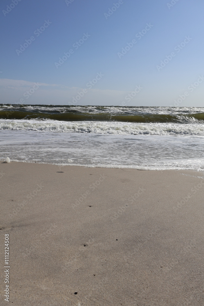 Minimalist View of a Sandy Beach with Ocean Waves. A clean, serene beach scene featuring untouched sand, gentle foam, and rolling waves under a clear blue sky. Minimalist View of a Sandy Beach with Ocean Waves. A clean, serene beach scene featuring untouched sand, gentle foam, and rolling waves under a clear blue sky.