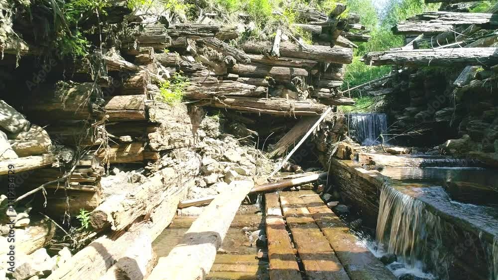 Wooden dam in wood, clean river stream, hillside and valley, mountain scenery picturesque, twilight sunlit hills Wooden dam in wood, clean river stream, hillside and valley, mountain scenery picturesque, twilight sunlit hills