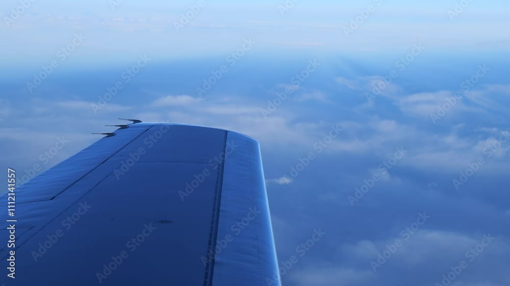 airplane wingtip background clouds cruising altitude close up panning shot view aviation scenic aircraft motion elevated perspective high design 