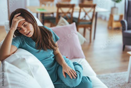 Exhausted Healthcare Worker Relaxing on Sofa After Long Shift at Home photo