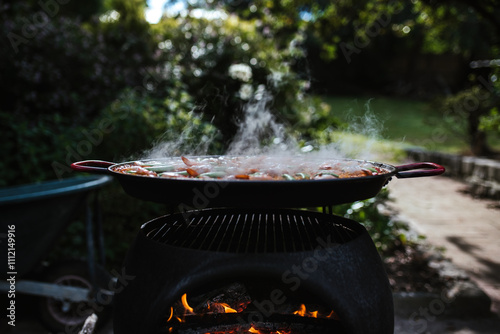 Paella cooks on an outdoor fire photo