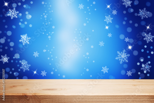 Festive christmas blue background with an empty wooden table, lights, and snowflakes.