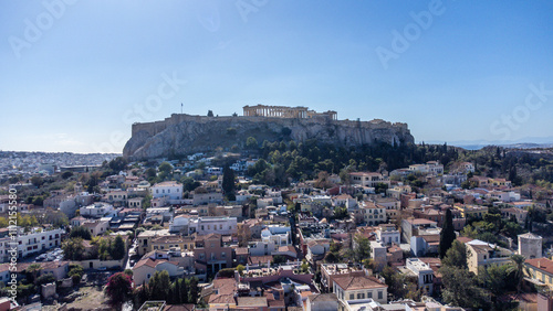 Visão aérea do Partenon na Acrópole de Atenas, destacando sua grandiosidade histórica e as casas próximas que compõem a paisagem urbana da capital grega photo