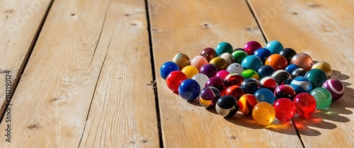 A vibrant collection of colorful marbles on sunbleached wooden background photo