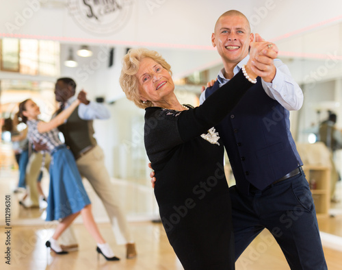 Cuadro en lienzo Elderly woman learning ballroom dancing movements in pair