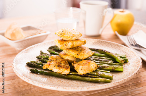 Cooked dish. Chicken nuggets with green asparagus on plate