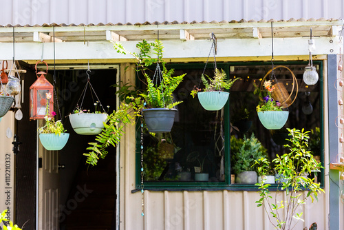 Hanging pot plant garden on porch of house with open door photo