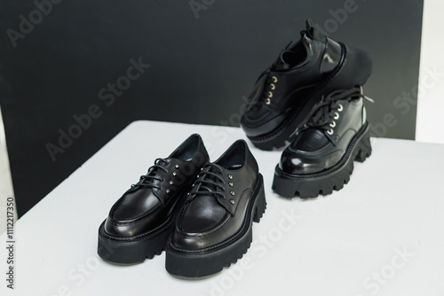 Obraz na płótnie Women's leather stylish black loafers on a white background, women's summer shoes close-up. Fashionable shoes for women. Selective focus w salonie