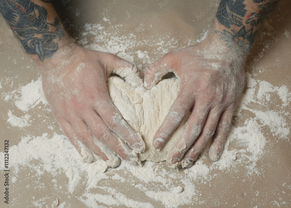 Fototapeta premium Tattooed arms working with dough.