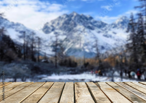 Wooden table top on blurred background mountains and forest nature Snow for important product editing or image layout design. View of the copy space.