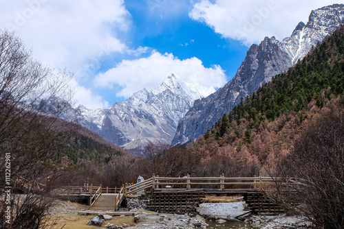 View of Tibetan sacred, holy snow mountains and hiking trail in one of the most idyllic national parks in China, Yading Nature Reserve, Sichuan Province  photo