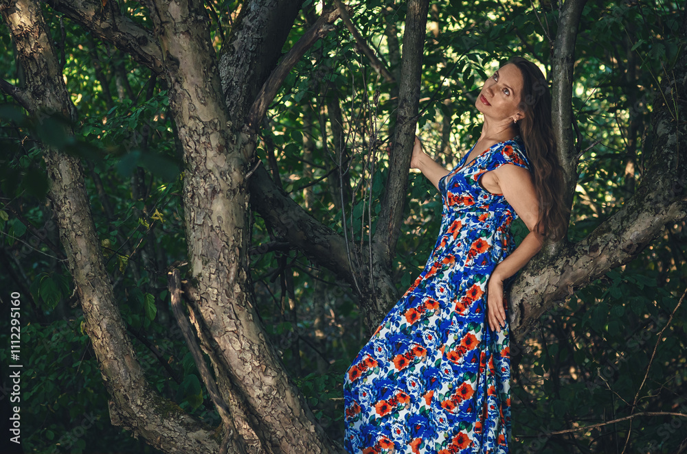 Adult lady on tree enjoying green nature. Forest around her. Concept of women and healthy natural lifestyle. Adult lady on tree enjoying green nature. Forest around her. Concept of women and healthy natural lifestyle.