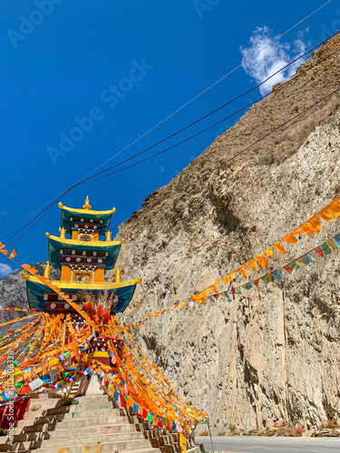 Views of Tibetan monastery, village, houses, green field and mountains along the road from Shangri La to Yading, Sichuan  photo