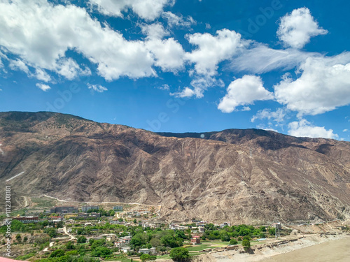 Views of Tibetan monastery, village, houses, green field and mountains along the road from Shangri La to Yading, Sichuan  photo