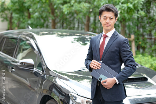 車の前に立つ男性