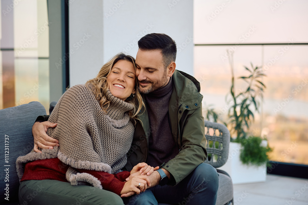 Loving couple enjoying in time together while relaxing on terrace. Loving couple enjoying in time together while relaxing on terrace.