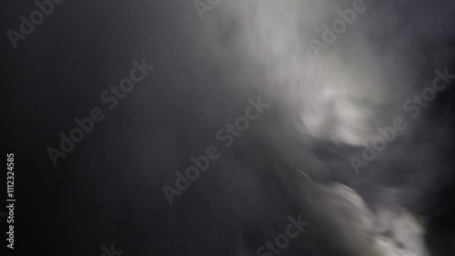 Abstract white smoke in slow motion. Smoke, Cloud of cold fog in light spot background. Light, white, fog, cloud, black background, 4k, ice smoke cloud. Floating fog.