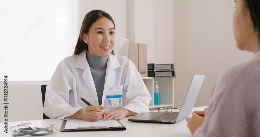 Adult female asia ill people see GP visit at clinic office. Young Therapist sit work on desk talk in test exam result, ask symptom, give advice, fill data on note paper chart form or order Rx pill. Adult female asia ill people see GP visit at clinic office. Young Therapist sit work on desk talk in test exam result, ask symptom, give advice, fill data on note paper chart form or order Rx pill.