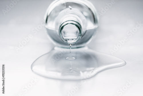 Close-up of a glass Bottle lying on table with water spilling out photo