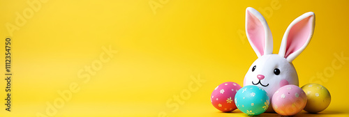 Colorful Easter eggs and bunny ears sit atop a bright yellow background with plenty of empty space surrounding them._00001_