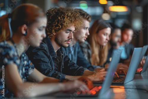 Team of male and female software developers writing code on laptops in real working environment.