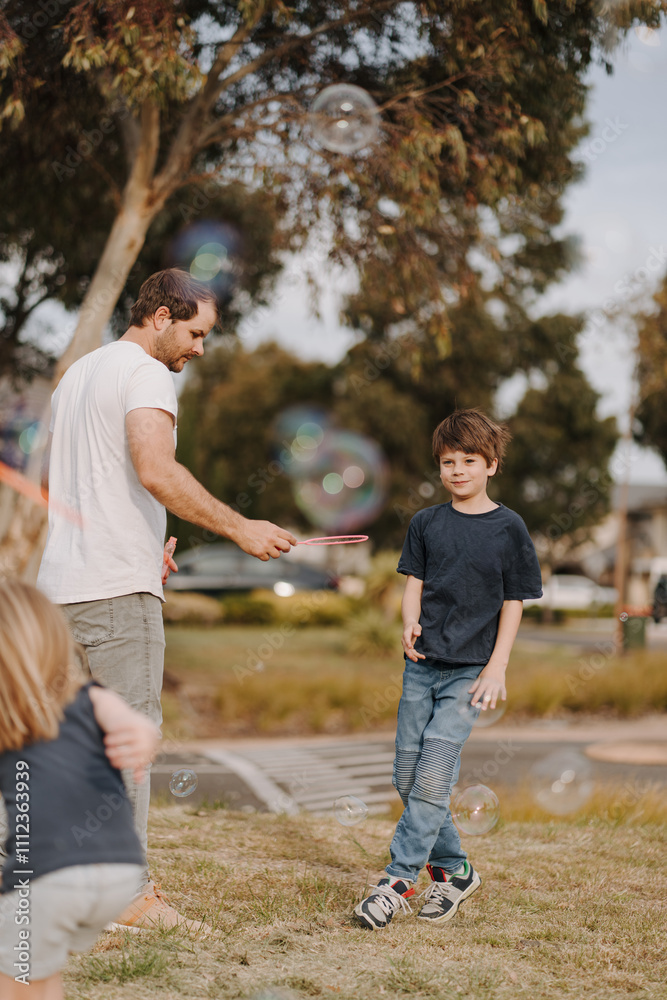 Happy family blowing and playing with bubbles in their yard. Happy family blowing and playing with bubbles in their yard.