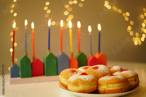 DIY Wooden Hanukkiah with Colorful Candles. High quality photo. The lit candles create a cozy and festive atmosphere with sufganiyet with lots of lights in the background  photo