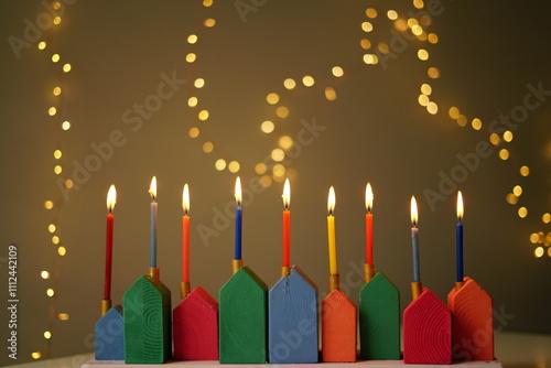 DIY Wooden Hanukkiah with Colorful Candles. High quality photo. The lit candles create a cozy and festive atmosphere, with lots of lights in the background. handmade menorah 