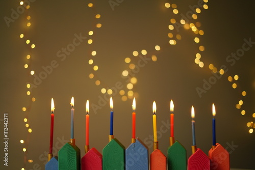 DIY Wooden Hanukkiah with Colorful Candles. High quality photo. The lit candles create a cozy and festive atmosphere, with lots of lights in the background. handmade menorah 