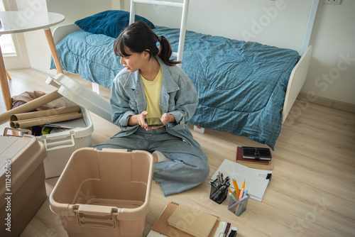 Student asian woman organize room unpack in dorm room college student moving to new  university dormitory or preparing to move out.