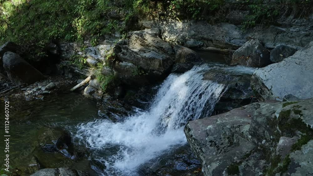 waterfall in the mountains on a sunny day waterfall in the mountains on a sunny day