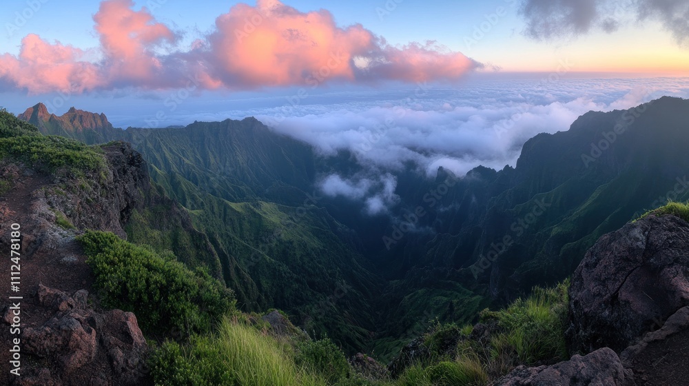 Fototapeta premium A stunning panoramic view of lush mountains and clouds at sunset.