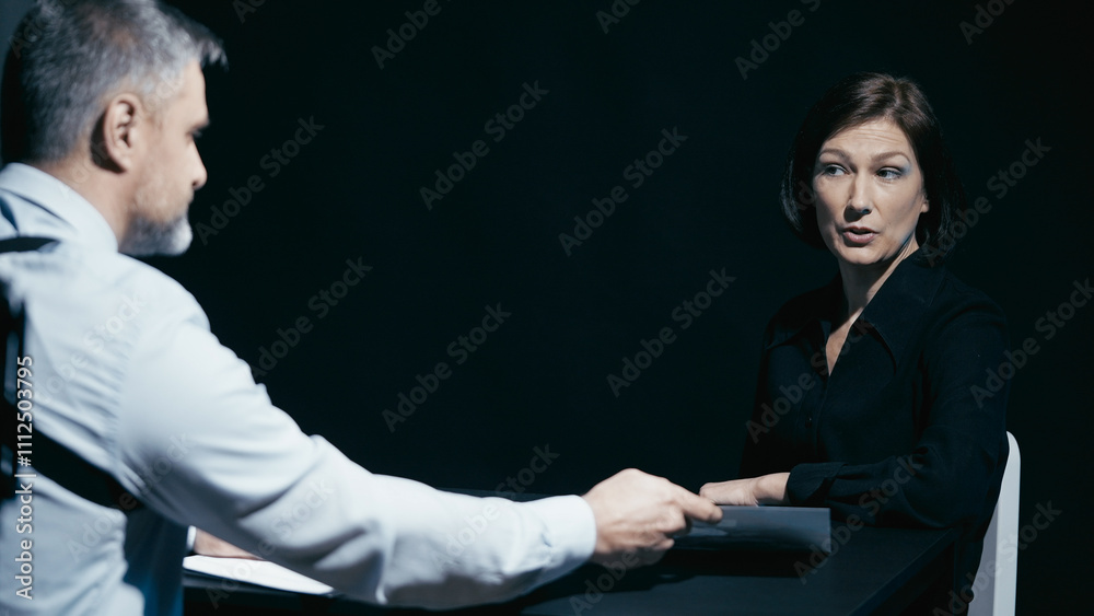 Detective shows a crime scene picture to a female suspect while questioning her in prison Detective shows a crime scene picture to a female suspect while questioning her in prison