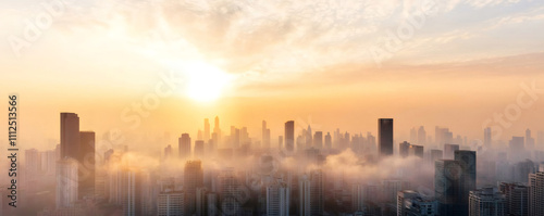 The breathtaking urban skyline emerges from the morning fog as the sky turns golden