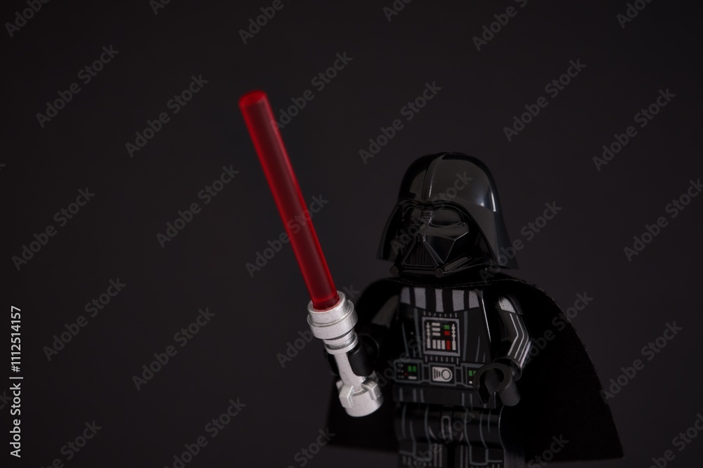 Naklejka premium Tambov, Russian Federation - November 14, 2024 Portrait of Lego Darth Vader minifigure with lightsaber against black background