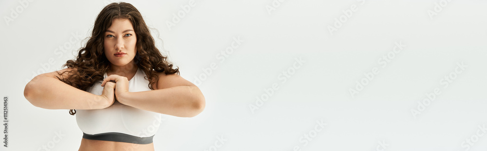 Naklejka premium Plus size woman confidently flaunts her beauty in stylish underwear against a soft backdrop.