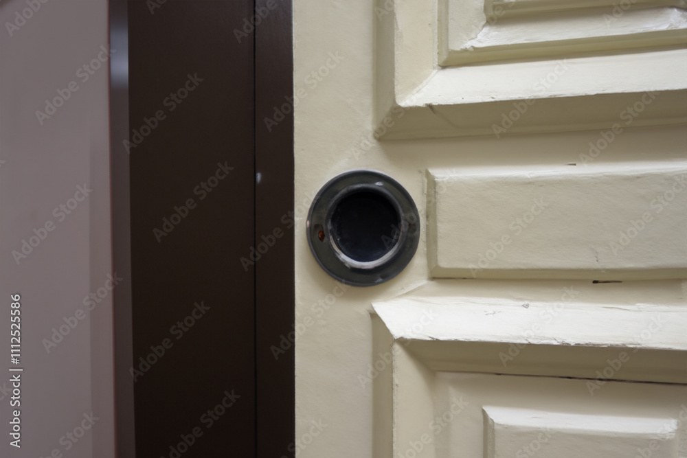 A door with a hole in it. Close up of a peephole with a silver door. Door silver peephole close up circle wooden. Wooden peepholes in the lifestyle door circle. A door with a hole in it. Close up of a peephole with a silver door. Door silver peephole close up circle wooden. Wooden peepholes in the lifestyle door circle.